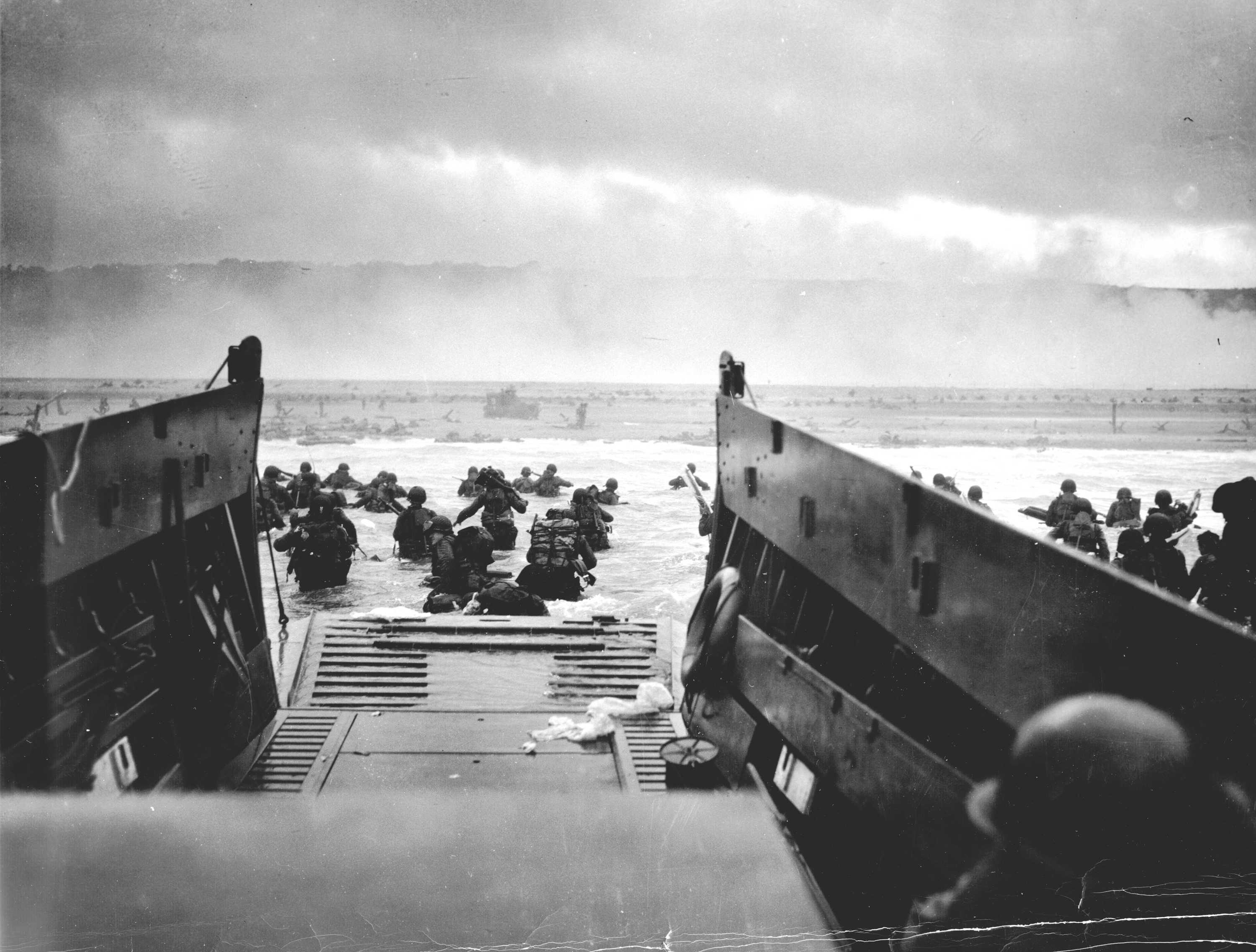 A Coast Guard-manned LCVP from the U.S.S. Samuel Chase disembarks troops of the First Division on the morning of 6 June 1944 at Omaha Beach